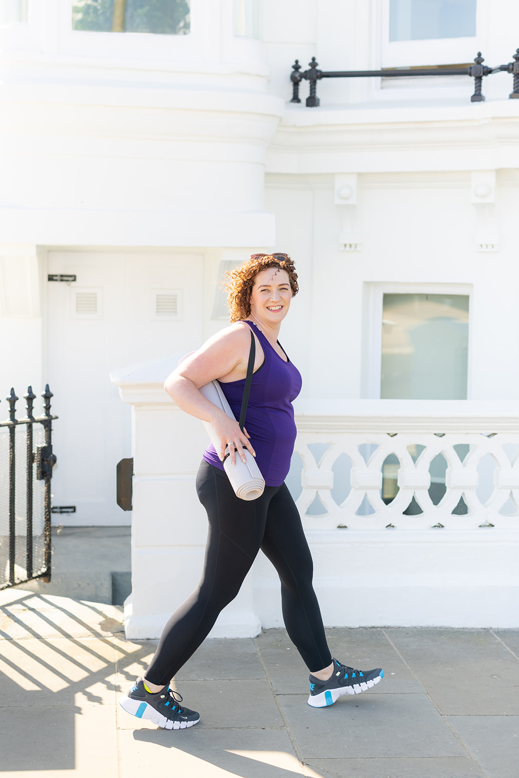 Personal trainer Becky Hughes walking with a yoga mat